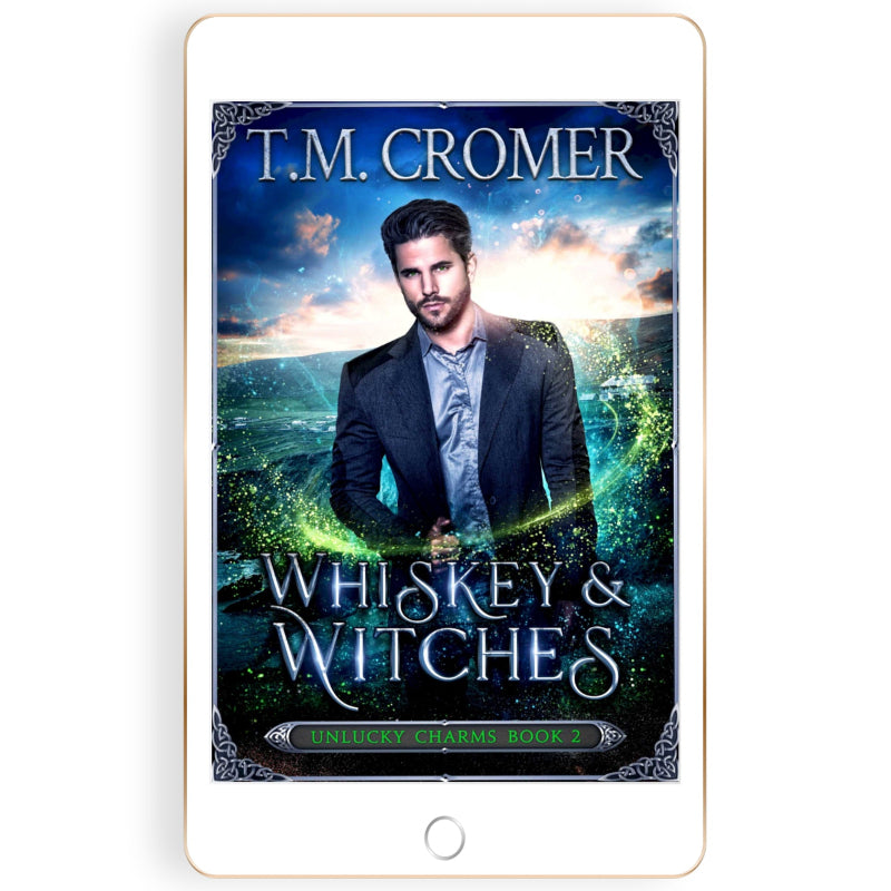 Book cover of 'Whiskey & Witches' by T.M. Cromer on a tablet screen.